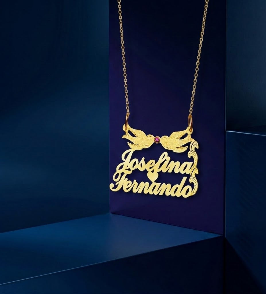 Artistic custom gold jewelry piece featuring engraved names, Lovebirds design, and ruby gemstone accent, created as a timeless and sentimental gift