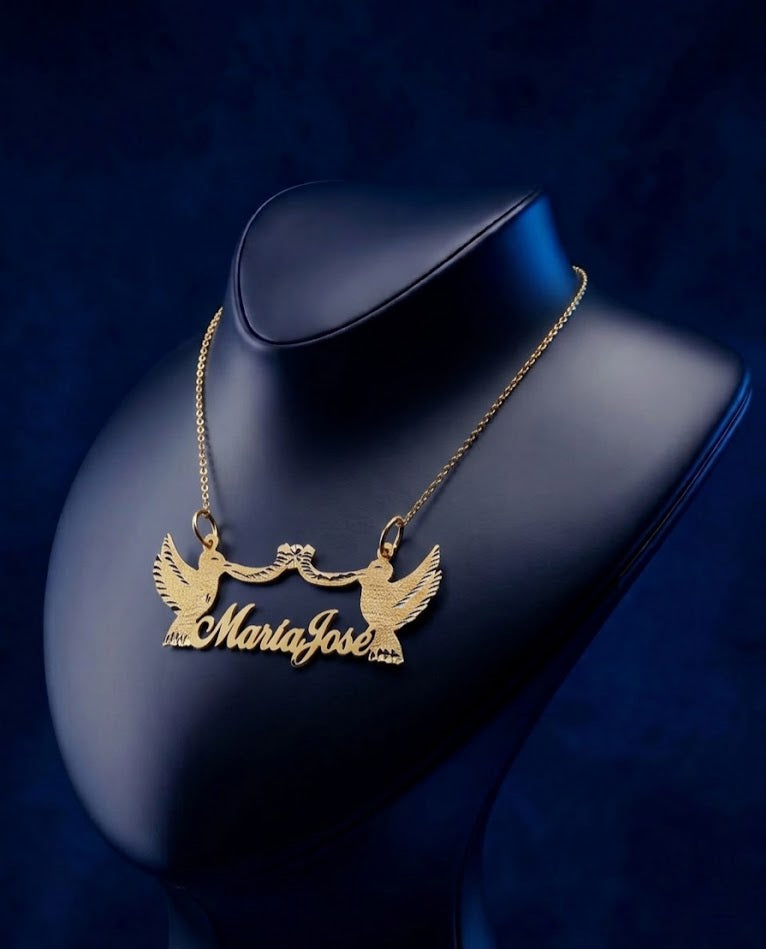 Luxury custom name necklace in 18k solid gold featuring double dove accents and ribbon-inspired bow detailing, handcrafted with refined artisan craftsmanship by CustomGolds INC