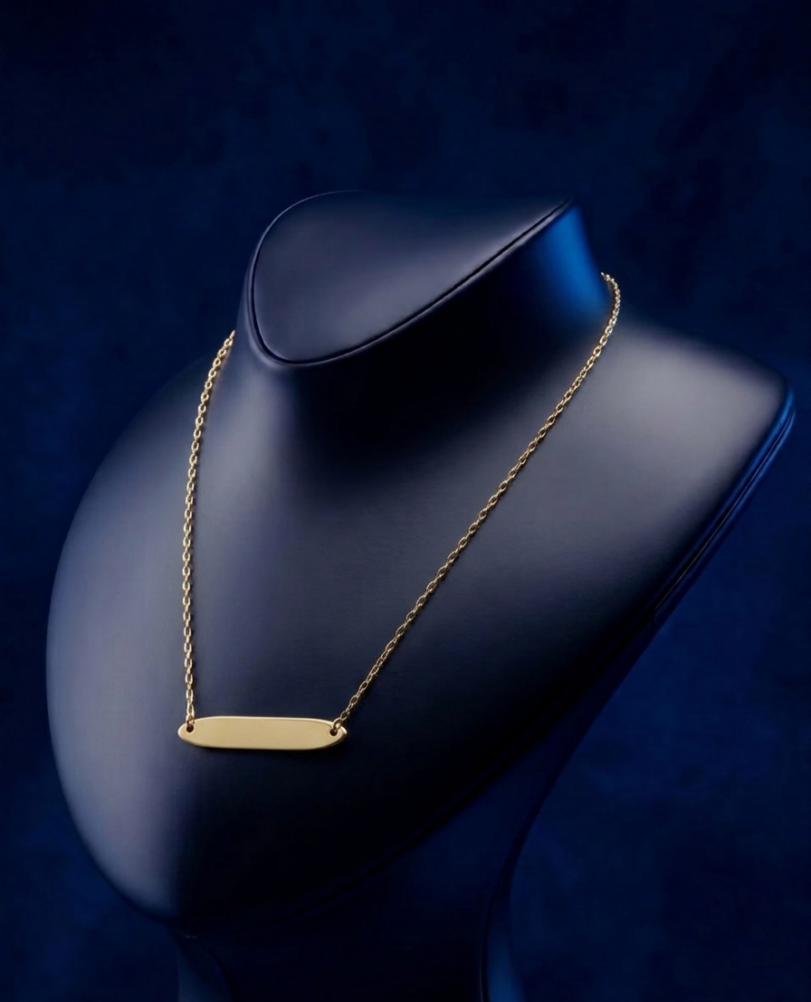 Custom 14k–18k gold oval bar necklace featuring engraved nameplate detail, soft satin polish, and premium bespoke craftsmanship in luxury jewelry by CustomGolds INC.