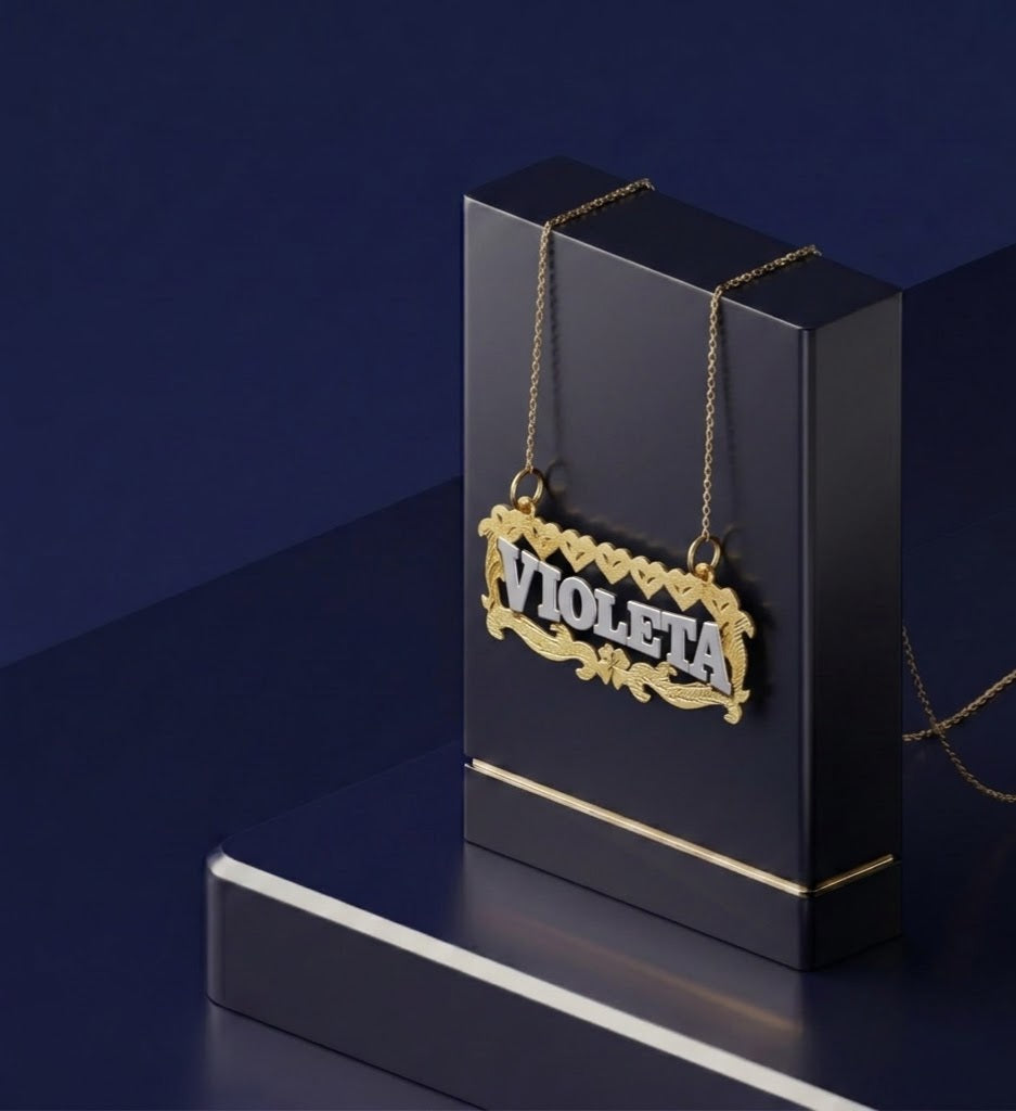 Personalized two-tone gold nameplate jewelry with shimmering diamond-cut hearts, detailed botanical scroll design, and a bespoke high-end custom gold lettering style.