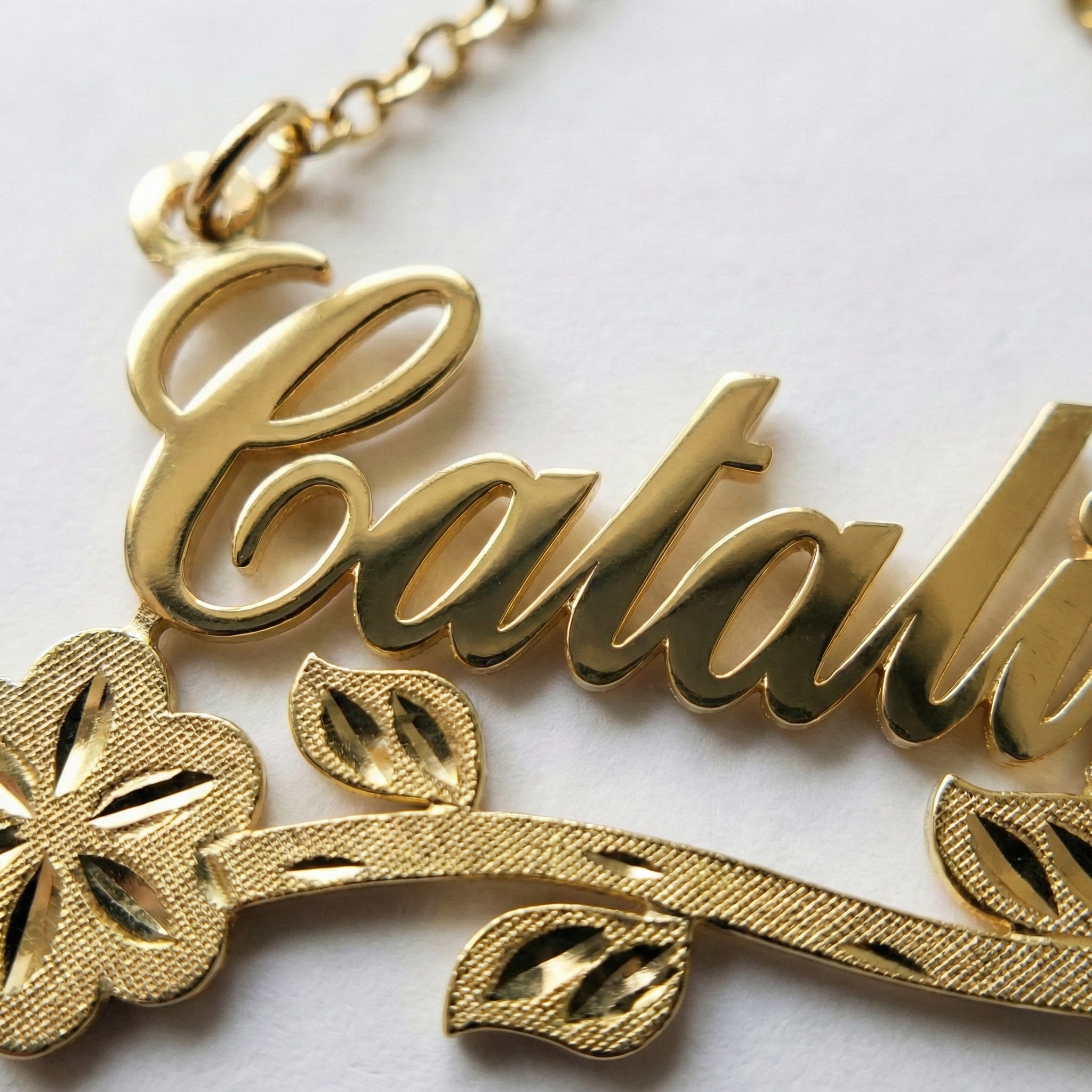 Gold necklace with 'Catalina' pendant on a white background