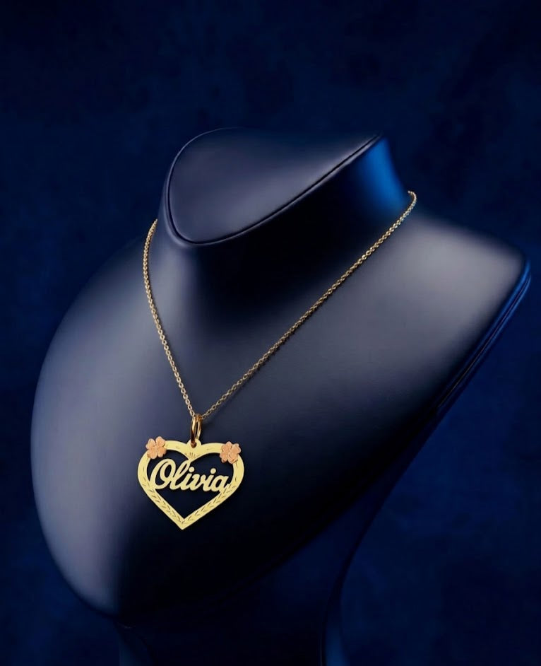 Personalized floral heart pendant necklace crafted in solid gold, showcasing custom name lettering with a soft satin-polish finish and fine jewelry craftsmanship.