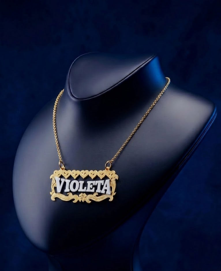 Luxury custom name necklace in 14k–18k gold tones with elegant script lettering, showcasing ornate floral scrollwork and a handcrafted nameplate pendant with premium finish.