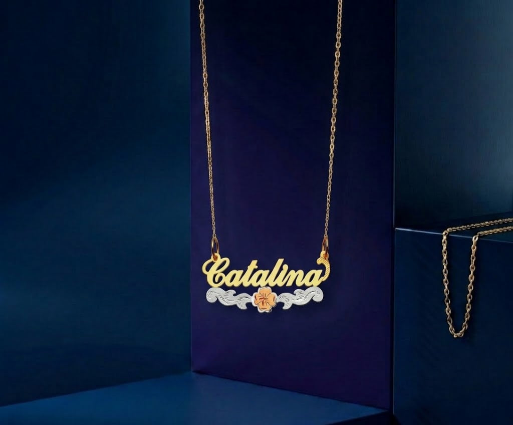 Premium personalized nameplate pendant with Hawaiian-inspired hibiscus flower artwork, featuring tri-color gold tones, master jeweler handcrafted details, and a radiant luxury custom design finish.