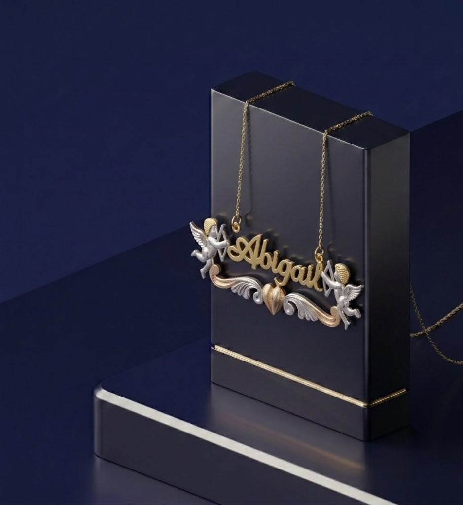 Luxury personalized nameplate necklace featuring 3D gold lettering, Cupid angel accent, and multi-tone heart design, handcrafted in Los Angeles fine jewelry studio with soft-polish satin and high-shine finish.