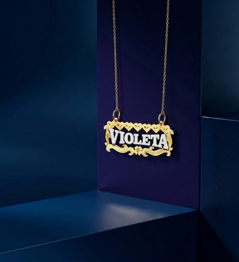 Handcrafted fine jewelry name necklace with dual-tone metal finish, decorative floral motifs, and polished script nameplate, designed as a luxury personalized gift from Los Angeles.